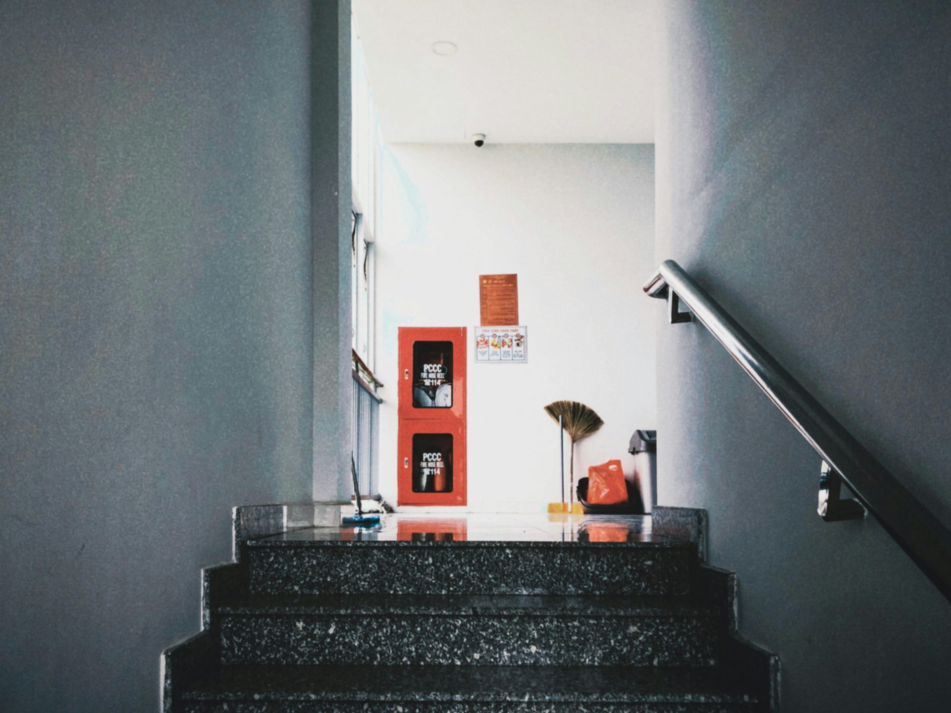 Eine Treppe mit einer roten Tür und einem roten Regenschirm